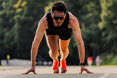 Atleta concentrado esperando el inicio para ganar la carrera de sprint de 100 metros.