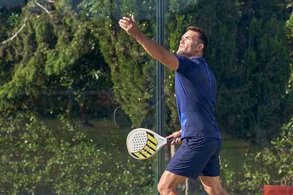 hombre jugando al pádel en la cancha